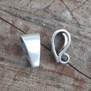 May include: Two silver-toned metal pendant bails. One bail is a simple, flat, triangular shape. The other bail is a curved, open loop.