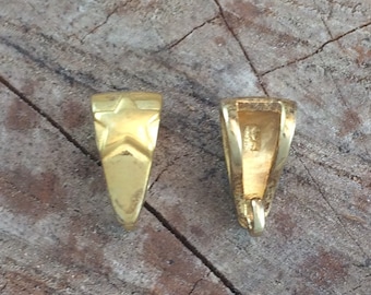 May include: Two gold-toned metal pendant bails with a star design on one side and a smooth surface on the other.