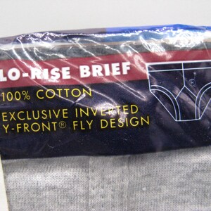 May include: A package of grey cotton lo-rise briefs featuring a dark blue label with white text that reads LO-RISE BRIEF, 100% COTTON, and EXCLUSIVE INVERTED Y-FRONT FLY DESIGN, accompanied by a white line drawing of the brief style.