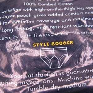 May include: A dark blue product package featuring white text describing 100% combed cotton underwear with a low waistline, high-on-the-thigh leg openings, and a two-layer pouch. The package displays the text STYLE 8006CR and a white line drawing of briefs.
