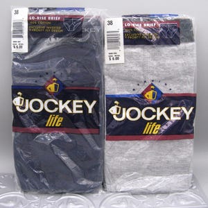 May include: Two packages of Jockey Life lo-rise briefs, one in navy blue and one in heather gray. Each package features the Jockey logo, the text 'Exclusive Inverted Y-Front Fly Design', '100% Cotton', and a size 38 label in clear plastic packaging.