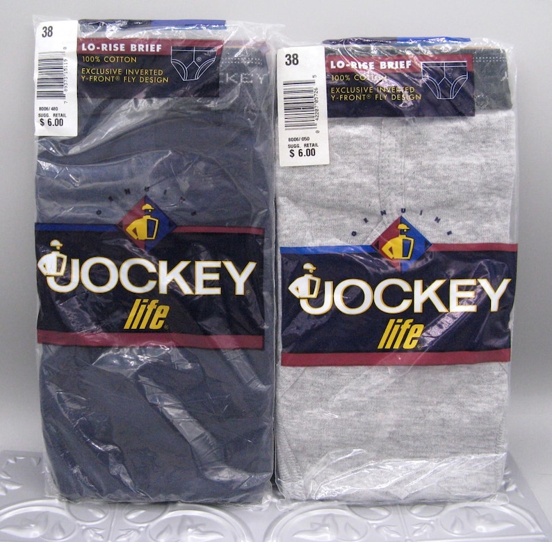 May include: Two packages of Jockey Life lo-rise briefs, one in navy blue and one in heather gray. Each package features the Jockey logo, the text 'Exclusive Inverted Y-Front Fly Design', '100% Cotton', and a size 38 label in clear plastic packaging.