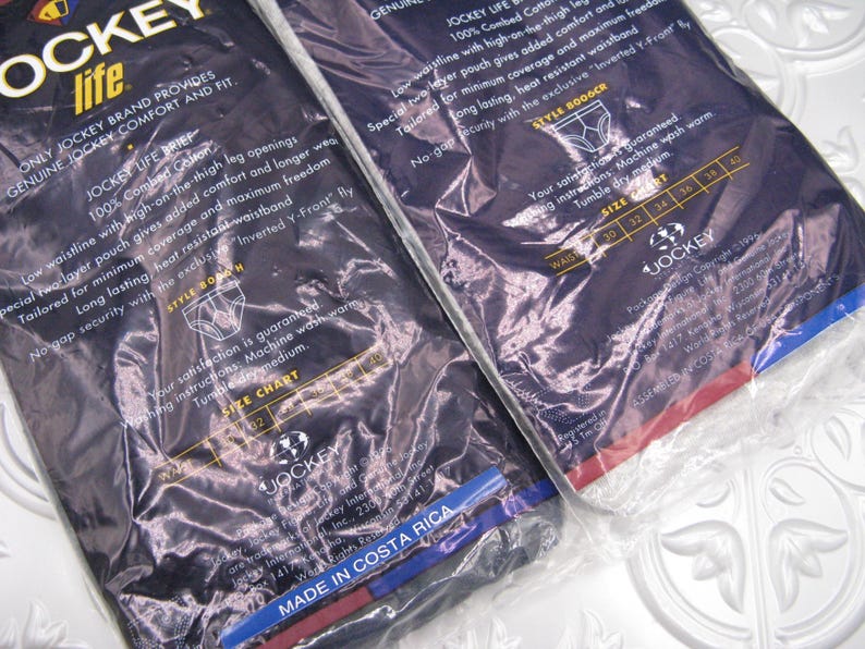 May include: Two packages of Jockey Life briefs in dark blue plastic wrapping. The packaging features white text detailing 100% combed cotton, a low waistline, high-on-the-thigh leg openings, a two-layer pouch, and an exclusive Inverted Y-Front fly.