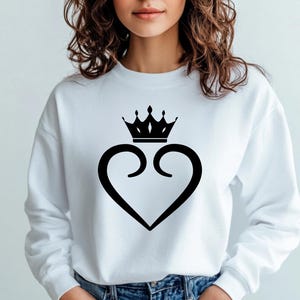 Pu&ograve; includere: Felpa bianca con un design a forma di cuore nero e una corona sopra il cuore.
