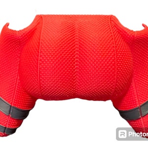 May include: Red and black controller skin with a textured surface. The skin has a black and gold trim around the edges.