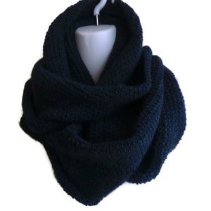 Op de afbeelding: Een donkerblauwe gebreide oneindige sjaal. De sjaal is gemaakt van een zacht, comfortabel materiaal en is perfect om warm te blijven in de winter.