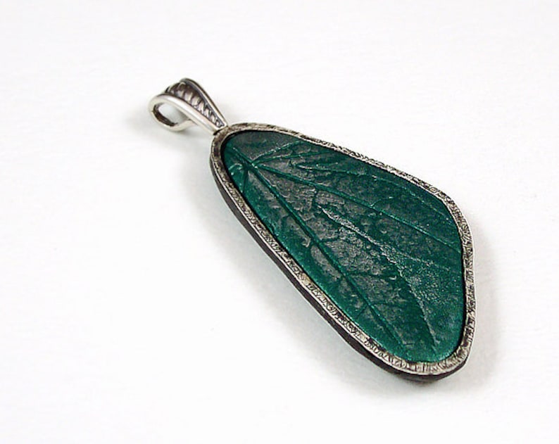 A picture of a polymer clay pendant with a DIY sterling silver bezel (frame).