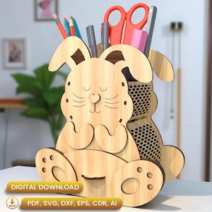 Pode incluir: Um organizador de mesa em forma de coelho de madeira com acabamento castanho claro. O organizador apresenta um rosto sorridente, orelhas compridas e um compartimento para canetas, lápis e tesouras. A base inclui o texto "DOWNLOAD DIGITAL" e opções de tipo de arquivo.