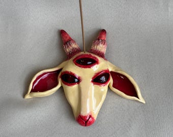 Wierookbrander in de vorm van een geit met drie ogen, bizarre surrealistische kunst, griezelig schattige occulte decoratie, handgemaakte asvanger van klei