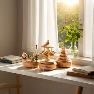 以下が含まれることがあります： 木製のオルゴール。馬のメリーゴーランドと、名前が刻まれた多層ケーキがあります。メリーゴーランドには木のキャノピーがあります。シーンは、日光と花瓶に入った花のある窓の近くの白い表面に設定されています。