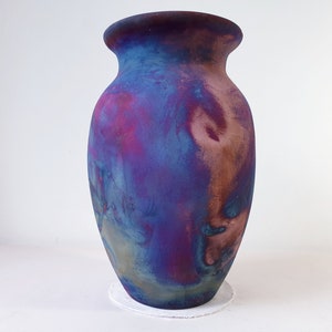 Può includere: Un vaso in ceramica con una smaltatura marmoreggiata blu, viola e marrone.