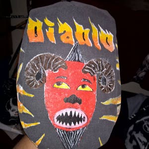 May include: A gray baseball cap with a red devil face and the word "Diablo" in yellow flames.