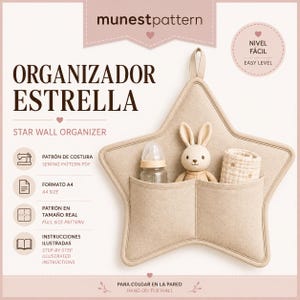 Può includere: Un organizer da parete a forma di stella in tessuto beige con due tasche frontali. Le tasche contengono un biberon, una piccola statuetta di coniglio e un panno piegato. Il testo sull'immagine include munestpattern, ORGANIZADOR ESTRELLA e STAR WALL ORGANIZER.