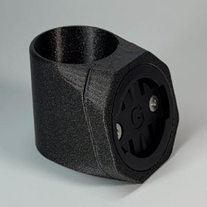 Könnte beinhalten: Schwarzer 3D-gedruckter Fahrradhalter mit einem schwarzen Garmin-Halter aus Kunststoff. Der Garmin-Halter hat zwei silberne Schrauben.