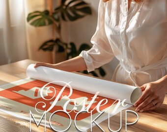 Op de afbeelding: Een persoon rolt een postermockup op een houten tafel op. De poster is oranje en heeft de tekst "Poster Mockup" erop gedrukt.