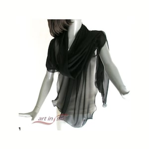 May include: A black sheer silk scarf draped over a mannequin. The scarf is lightweight and flowing, with a slightly ruffled edge. The words "art in silk" are printed on the bottom left of the image.