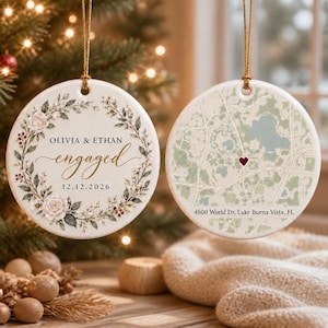 May include: Two round white ceramic ornaments with gold hanging strings. One features a floral wreath, the text OLIVIA & ETHAN engaged, and 12.12.2026. The other displays a map with a red heart and the text 4600 World Dr, Lake Buena Vista, FL.