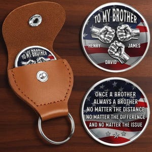 May include: A brown leather coin holder with a silver keyring, holding a coin that says "TO MY BROTHER". Two additional coins are visible, one with the names "Henry", "James", and "David", and another with a quote.