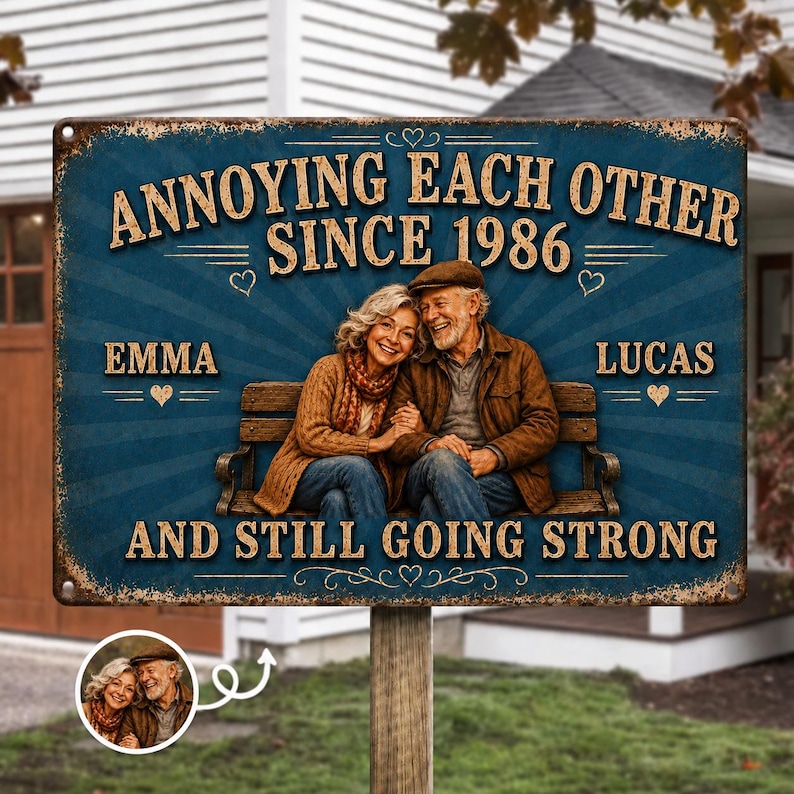K&ouml;nnte beinhalten: Ein rechteckiges Metallschild mit verwittertem blauem Hintergrund und einer zentralen Illustration eines &auml;lteren Paares auf einer Bank. Der Text lautet: ANNOYING EACH OTHER SINCE 1986, EMMA, LUCAS, AND STILL GOING STRONG. Ein kleiner runder Einsatz zeigt das Paar.