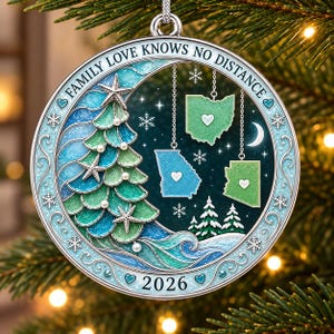 Könnte beinhalten: Ein runder, silberfarbener Weihnachtsschmuck mit einem stilisierten Baum, Seesternen und Perlen, drei hängenden Landkarten mit Herzen sowie dem Text "FAMILY LOVE KNOWS NO DISTANCE" und "2026" in Blau- und Grüntönen mit Schneeflocken-Motiven.