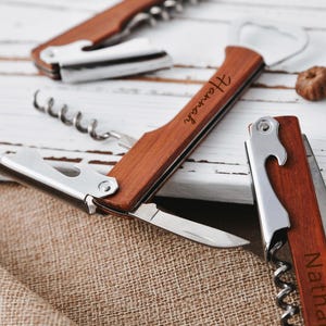 May include: Two wooden bottle openers with corkscrews and bottle cap openers. One opener is engraved with the name "Hannah" and the other is engraved with the name "Nathaniel".