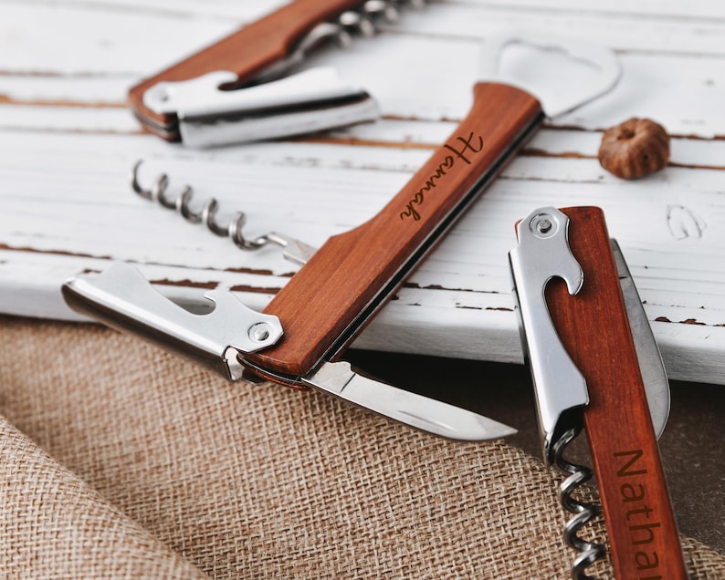 May include: Two wooden bottle openers with corkscrews and bottle cap openers. One opener is engraved with the name "Hannah" and the other is engraved with the name "Nathaniel".