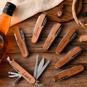May include: Set of six wooden pocket knives with personalized names: Laura, Claire, Ameera, Shaani, Fiona, and Harriet. Each knife has a wood handle and multiple tools.