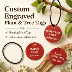 May include: Three circular red metal plant and tree tags with engraved white text. One tag reads HONEYCRISP APPLE PLANTED 2025, another MAPLE TREE EST. 2025, and the third LILAC SENSATION MAR 2025. Two black cable attachments with silver screw fasteners.