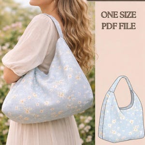 Op de afbeelding: Een halvemaanvormige schoudertas van lichtblauwe stof met een wit madeliefjespatroon. De afbeelding bevat de tekst Crescent Shoulder Bag, ONE SIZE, PDF FILE, samen met een technische lijntekening van het tasontwerp.