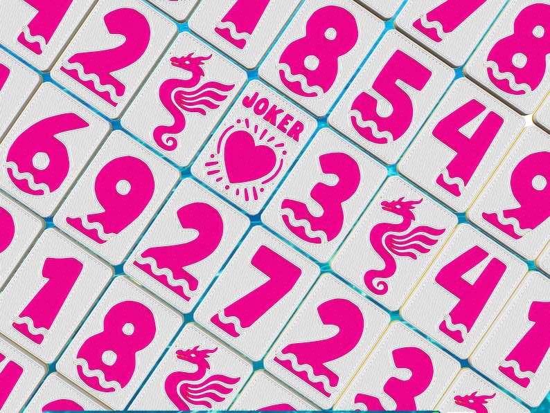 May include: Close-up of a collection of white game tiles with bright pink numbers, dragon illustrations, and the word "JOKER" with a heart symbol. The tiles are arranged in a grid pattern with a light blue background.
