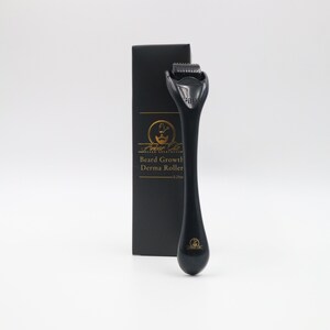 May include: A black derma roller for beard growth, with a handle and a roller head covered in tiny needles. The product is displayed next to a black box with gold text that reads "Ambar Oils Beard Growth Derma Roller - 0.25mm."