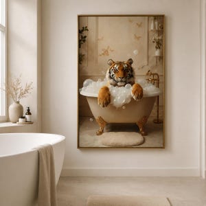 Op de afbeelding: Een ingelijste muurkunstprint met een tijger in een beige bad op pootjes gevuld met witte zeepbellen. De tijger heeft een oranje en zwarte vacht en het bad is voorzien van goudkleurige pootjes en een gouden kraan tegen een neutrale muur.