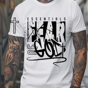 May include: White t-shirt with the text "ESSENTIALS FEAR GOD" in black, with a cross graphic on the left sleeve. The shirt also has the words "ONLY DIGITAL DOWNLOAD" and "INSTANT DOWNLOAD" in the image.