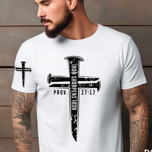 Puede incluir: Camiseta blanca con un diseño de cruz negra con el texto "Iron Sharpens Iron" y "Prov. 27:17". Una cruz más pequeña está en la manga izquierda. La imagen también incluye las palabras "Only Digital" y "Instant Download".
