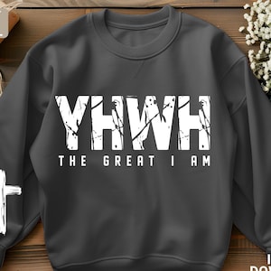 Pode incluir: Uma camisa de moletom cinza escura com um design gráfico branco que diz "YHWH THE GREAT I AM".
