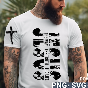 Może przedstawiać: Biały T-shirt z czarnym nadrukiem graficznym, na którym widnieje napis "JESUS" oraz słowa "The Way, The Truth, The Life" napisane pionowo obok niego. Po lewej stronie koszulki znajduje się czarny krzyż.