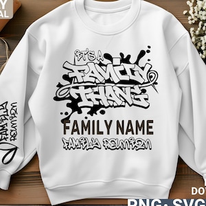 May include: White sweatshirt with a black and white graphic design that says "It's a Family Thing" in a graffiti style. The text "FAMILY NAME" and "FAMILY REUNION" are also included in the design.