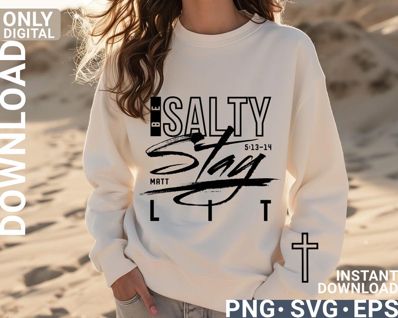 May include: Cream-colored sweatshirt with the words "BE SALTY Stay LIT" in black lettering. The design includes a cross on the sleeve and the text "MATT 5:13-14". The sweatshirt is a digital download.