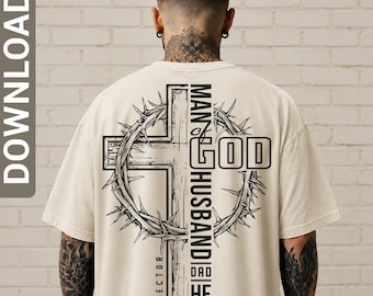 May include: A beige t-shirt featuring a black graphic on the back. The design displays a large cross encircled by a crown of thorns. The text reads MAN OF GOD, HUSBAND, DAD, HERO, and PROTECTOR. The graphic is printed in a bold, black ink style.