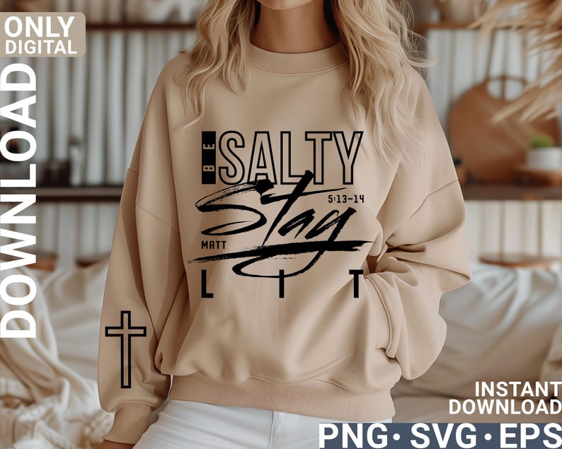 May include: A beige sweatshirt with the text "BE SALTY" in black, with "Stay Lit" in a script font. The sleeve has a black cross. The image also includes "MATT 5:13-14" and "ONLY DIGITAL DOWNLOAD".