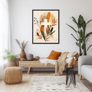 Puede incluir: Una impresi&oacute;n enmarcada con una cruz blanca rodeada de formas abstractas y follaje en tonos naranja, marr&oacute;n y verde. El fondo es beige claro.