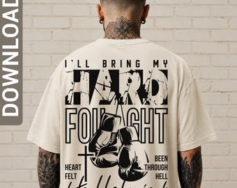 May include: A beige t-shirt featuring a black graphic design on the back. The text reads I'LL BRING MY HARD FOUGHT HEART FELT BEEN THROUGH HELL HALLELUJAH. The design includes a pair of boxing gloves and a cross, with distressed lettering.