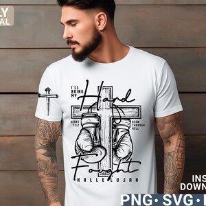 May include: White t-shirt with a black graphic design featuring a cross, boxing gloves, and the words "I'll Bring My Hand Fight Hallelujah." The design includes the text "Heart Felt" and "Been Through Hell."
