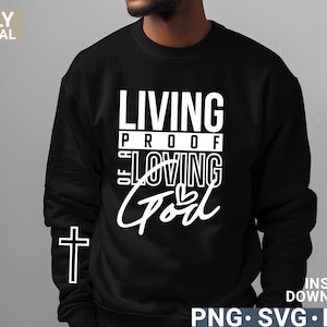 Può includere: Felpa nera con testo bianco che recita "Living Proof of a Loving God" con una piccola grafica a forma di cuore.