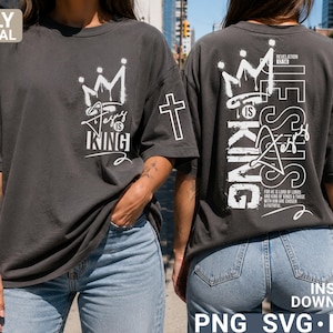 Puede incluir: Camiseta gris oscuro con la frase "Jesus is King" y un gr&aacute;fico de corona en la parte delantera. La parte trasera de la camiseta presenta la frase "Jesus is King" verticalmente, con texto adicional y un gr&aacute;fico de corona. Una cruz est&aacute; en la manga.
