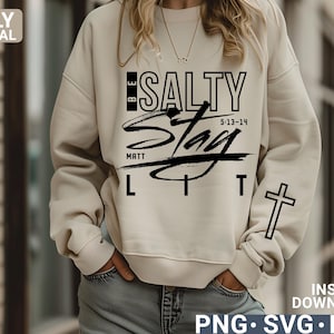 May include: Beige sweatshirt with the text "BE SALTY STAY LIT" in black, along with the scripture reference 5:13-14 and the word "MATT". A black cross is on the right sleeve. The words "ONLY DIGITAL DOWNLOAD" are on the left side.