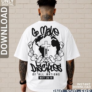 May include: A white t-shirt featuring a black graphic on the back. The design shows two hands cupping a globe with a cross in the centre. The text reads Go Make Disciples of All Nations and Matt 28:19 in a bold, stylised, graffiti-inspired font.