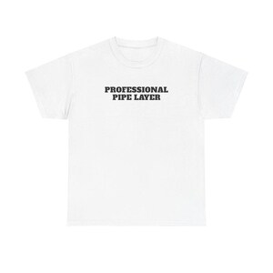 May include: A white t-shirt with the text "PROFESSIONAL PIPE LAYER" printed in black, centered on the chest. The shirt has a crew neck and short sleeves. The fabric appears to be a soft, comfortable material.