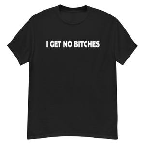 May include: Black t-shirt with the white text "I GET NO BITCHES" across the chest. The shirt is a short-sleeved crew neck style. The text is in a bold, sans-serif font.