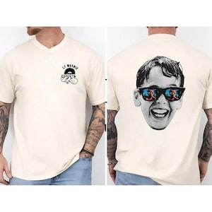 May include: A white t-shirt with a black and white graphic of a record player with the text "LJ WEENIE" on the front. The back of the shirt features a black and white image of a boy wearing sunglasses with a reflection of a pool in the lenses. The boy is smiling.